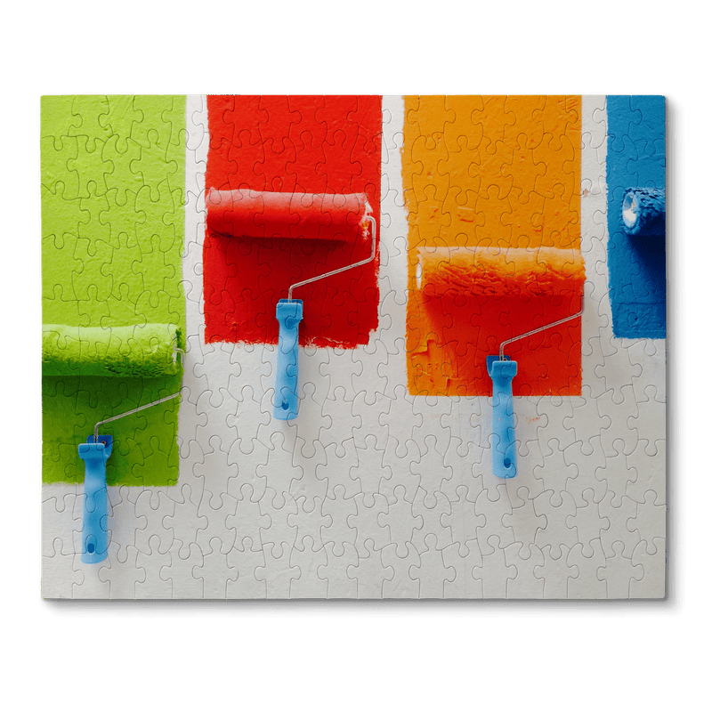 Puzzle with four paint rollers painting different bright colors
