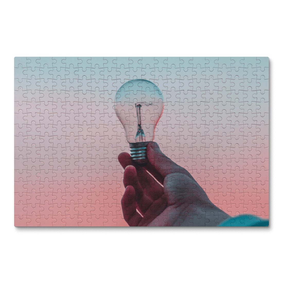 A picture of a hand holding a light bulb with a gradient background on a puzzle