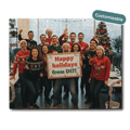 Group of people in festive sweaters with a 'Happy holidays from D17!' sign, surrounded by Christmas decorations.