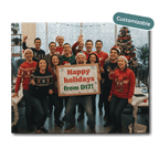 Group of people in festive sweaters with a 'Happy holidays from D17!' sign, surrounded by Christmas decorations.